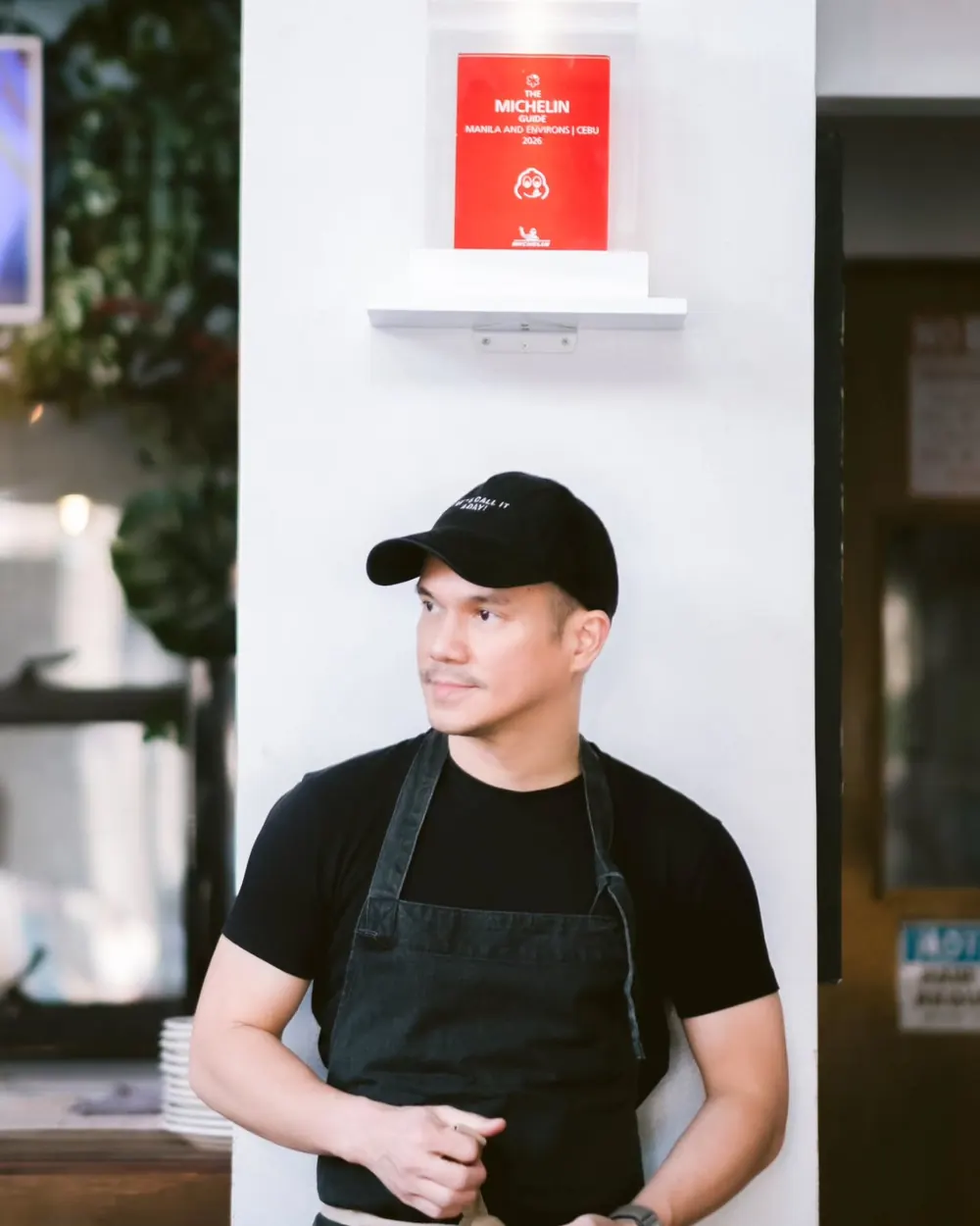Chef Miggy Cabel Moreno in a black cap and apron inside Palm Grill.
